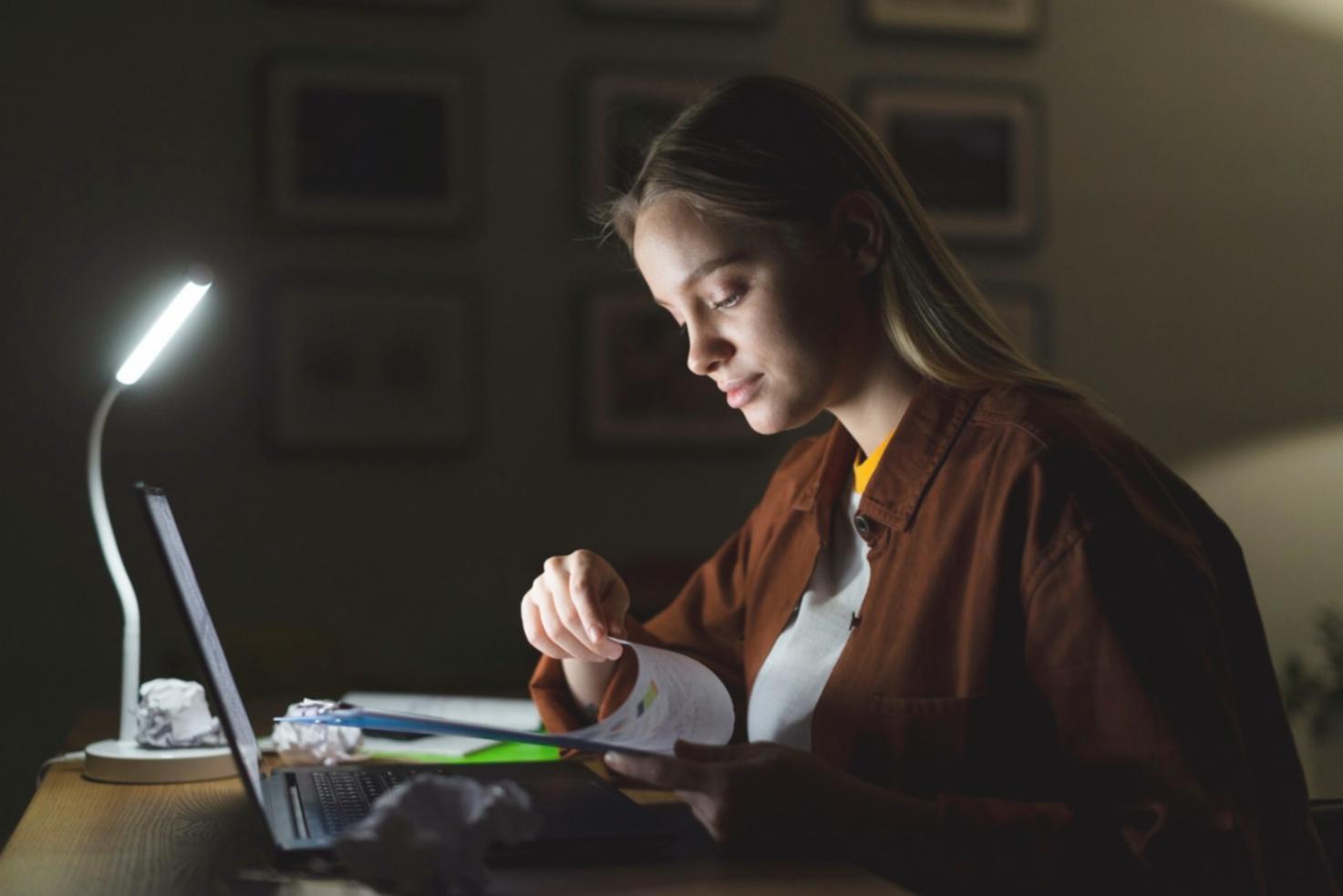 Students analyzing financial data on multiple screens showing market charts and company reports